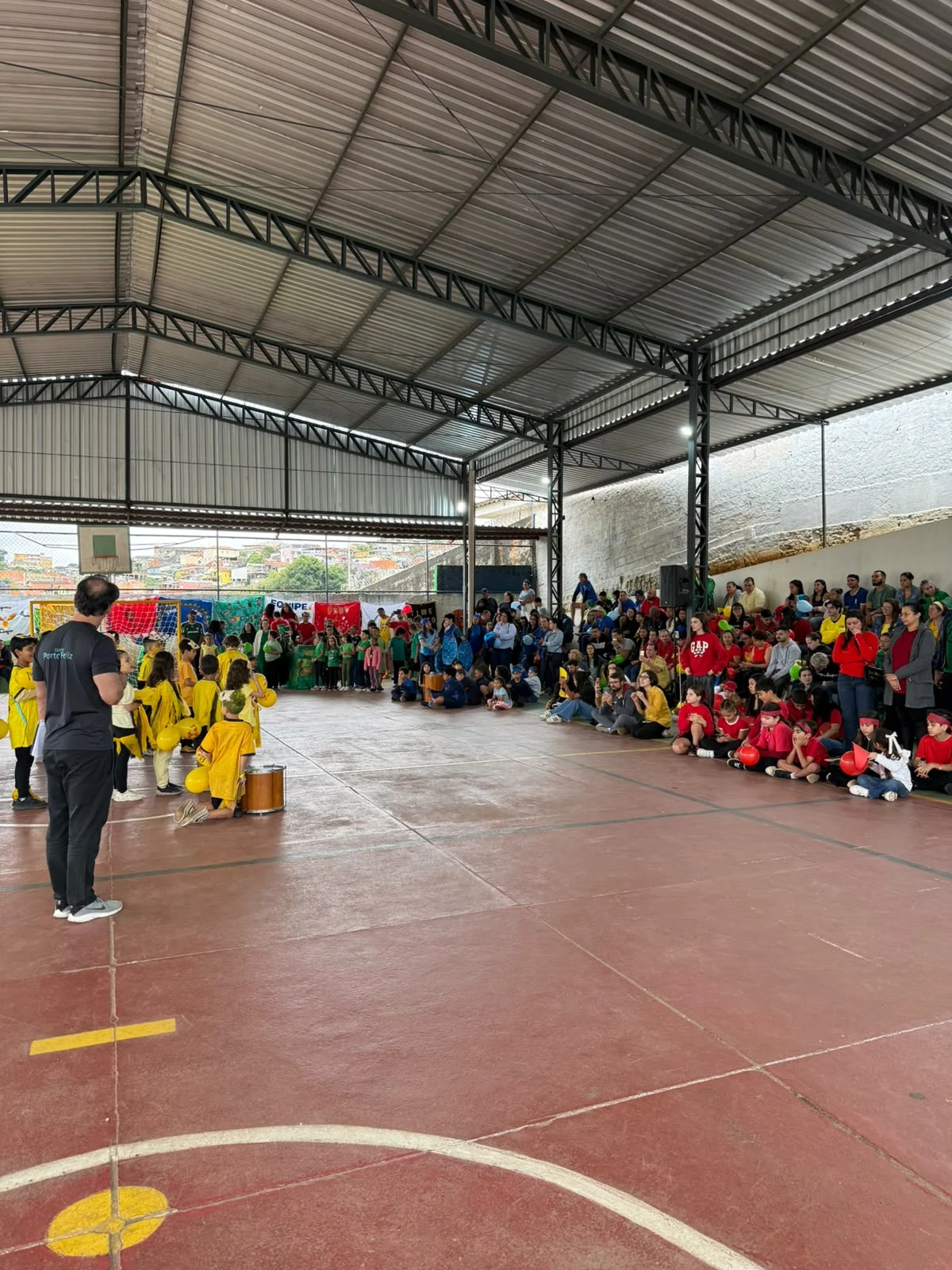 Estudantes e equipe reunidos na quadra coberta